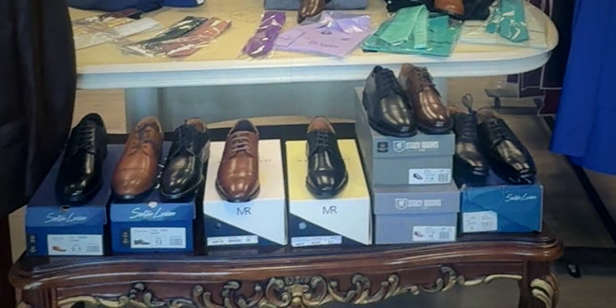 Black, brown and cognac dress shoes displayed on their boxes on a carved wooden table